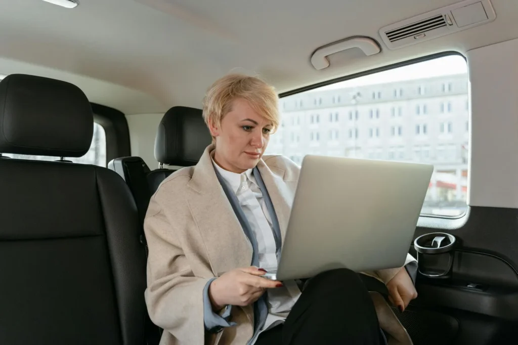 woman working while sitting inside of a car